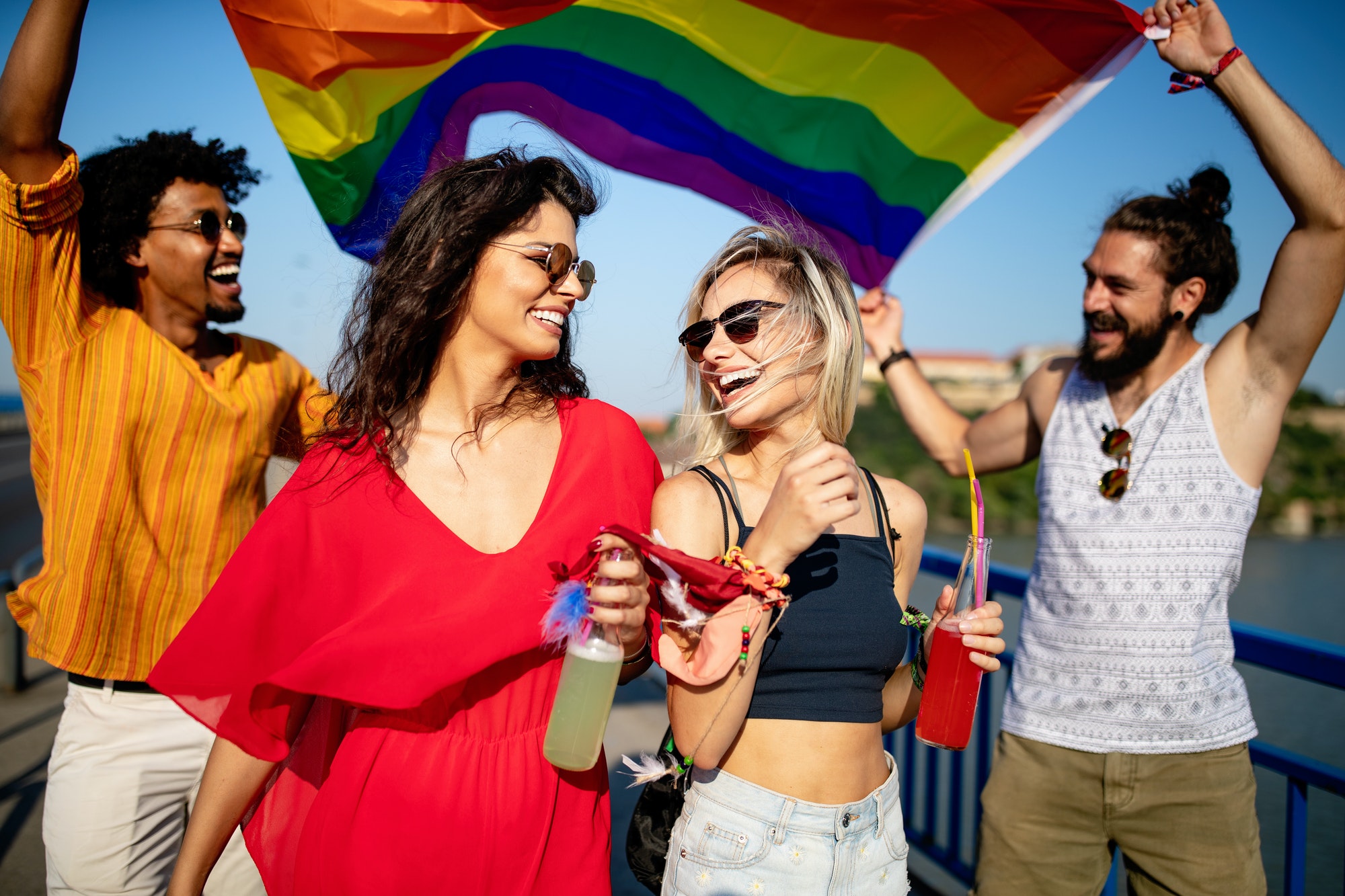 Pride homosexual, lesbian, gay community at a parade with hands raised and the LGBT flag